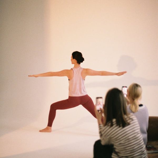 Woman in a peaceful yoga pose inside a modern, bright studio.